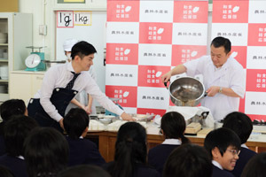 	食育の授業でだしをひく奥田透さん(右側)
