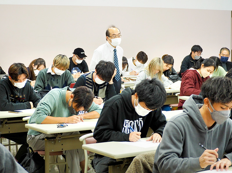 写真１　詩を読み、作者に手紙を書く、詩の続きを書くワークに取り組む学生。