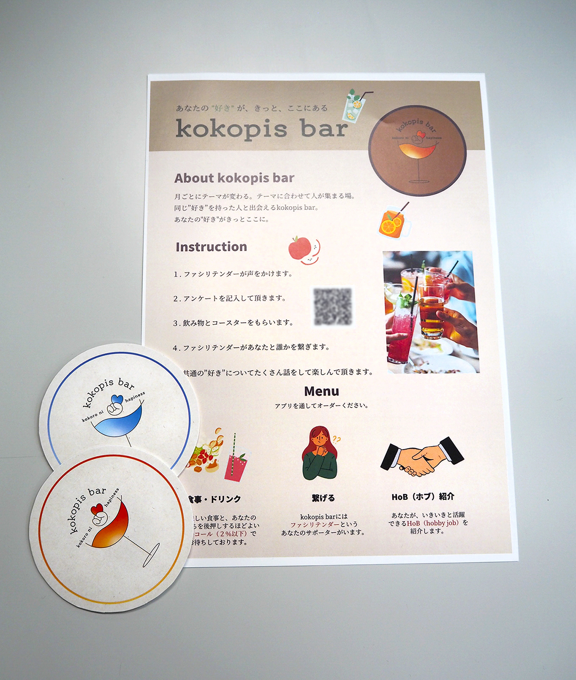 写真４　毎月テーマを設けて、人との出会いを後押しするBarの発表では、入店者に配布するBarの説明書と使用するコースターを会場にいる全員に配布し、Barを具体的にイメージできるようにしていた。