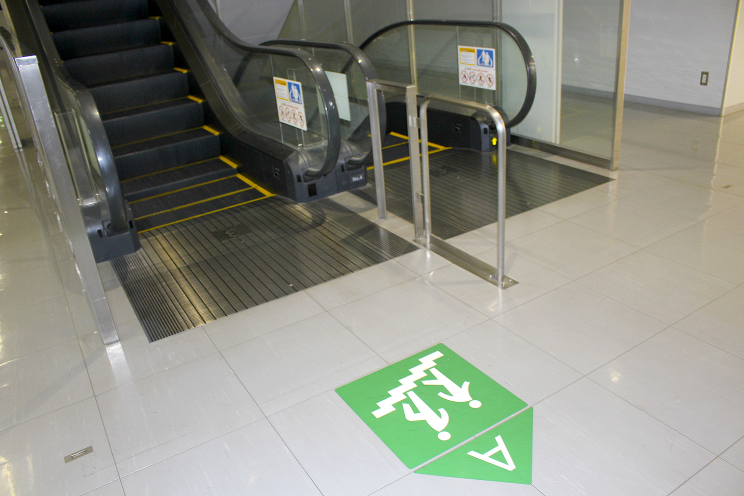 写真２　エスカレーターの踊り場には、学生が設計した手すりが設けられ、床には階段に誘導するステッカーが実際に貼られている。人の流れに秩序が生まれ、危険を感じる場面が減ったという。