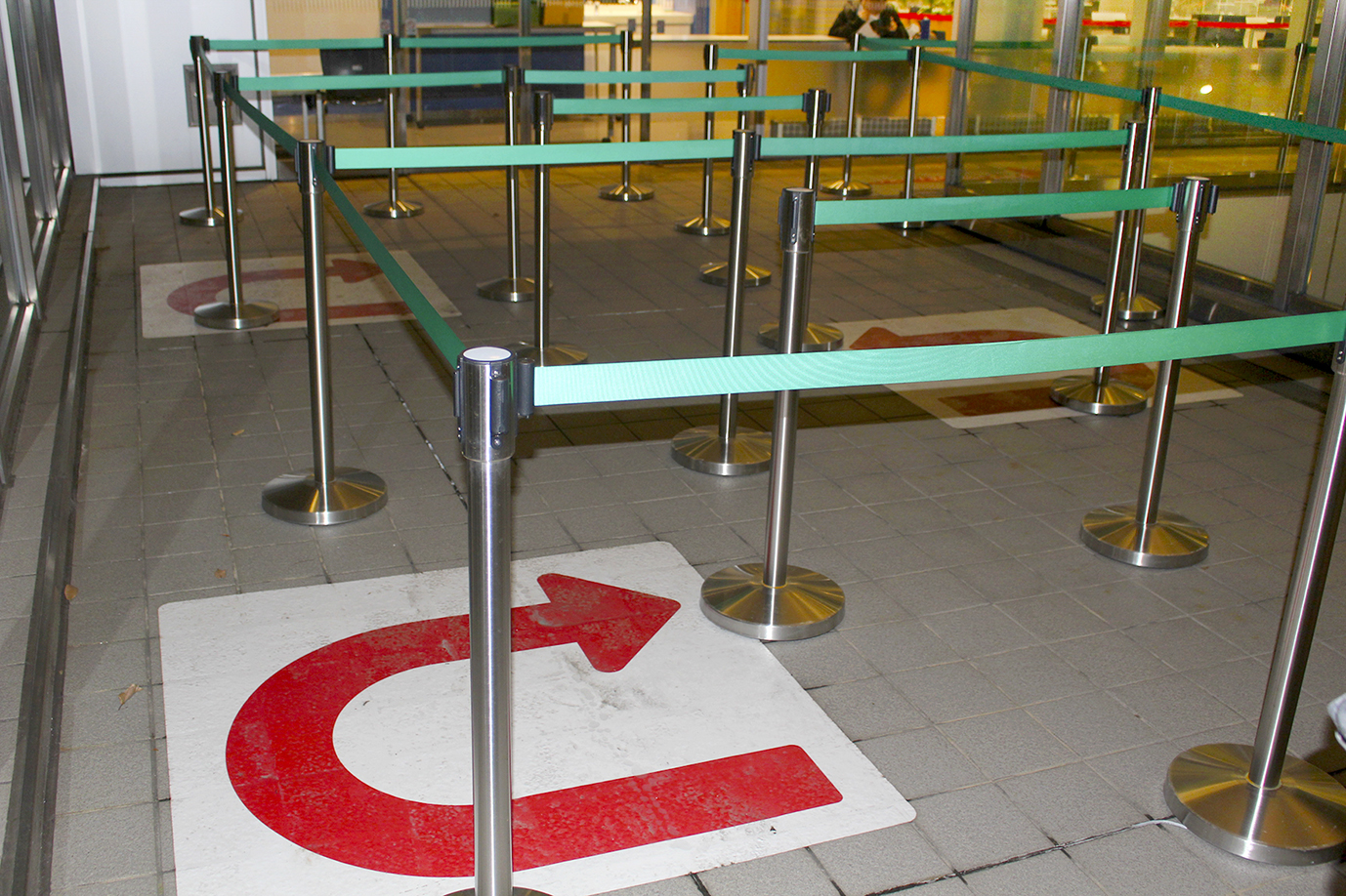 写真５　人の流れを誘導する矢印や整列テープを設置すると、学生は整然と並ぶようになり、通行がスムーズとなった。