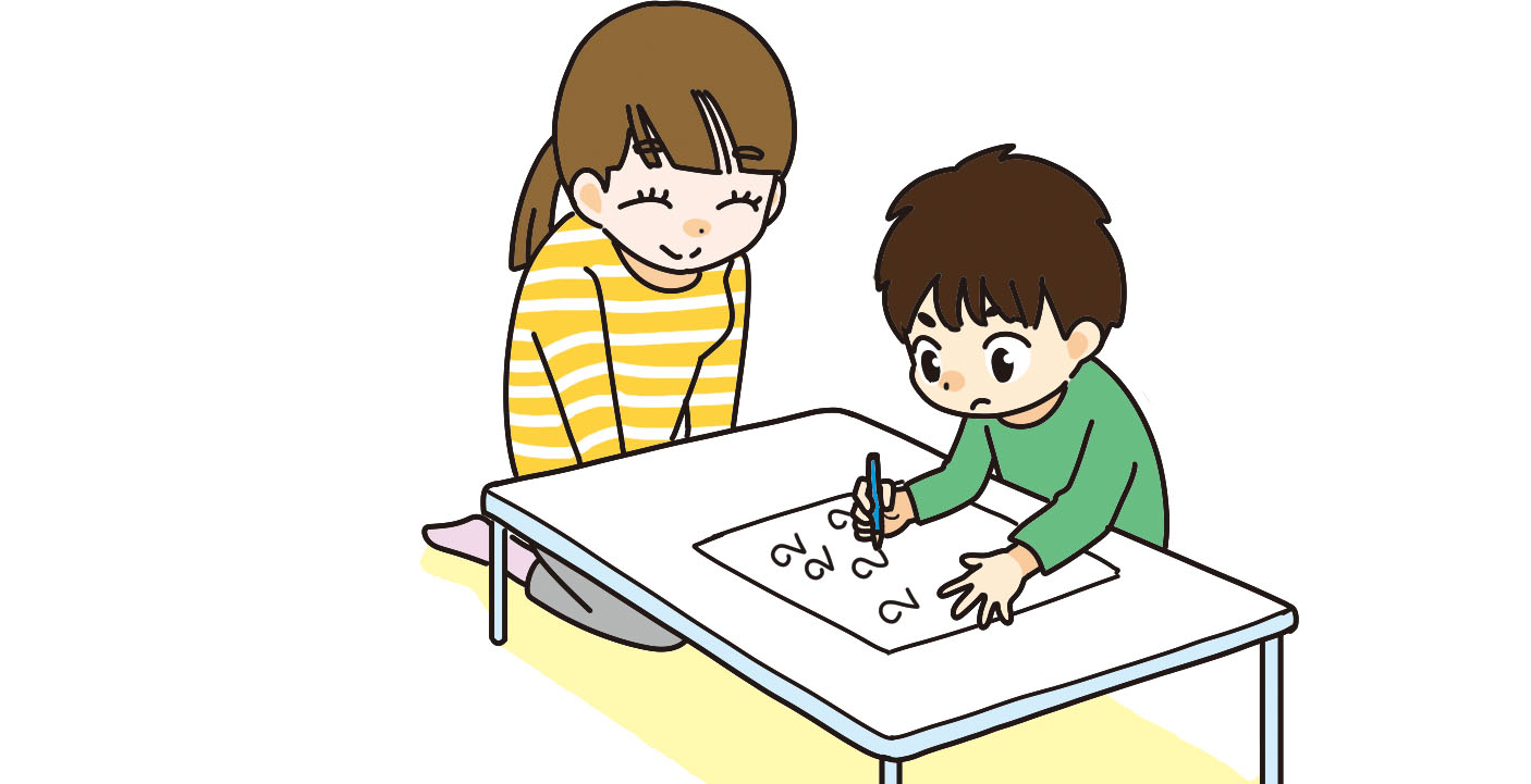 机に向かって学習する子供と見守る親