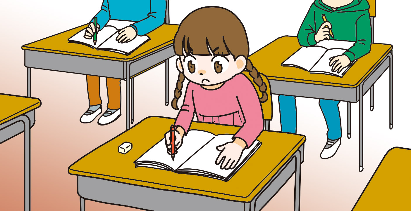 学校で授業を受けながら熱心にノートをとる子ども