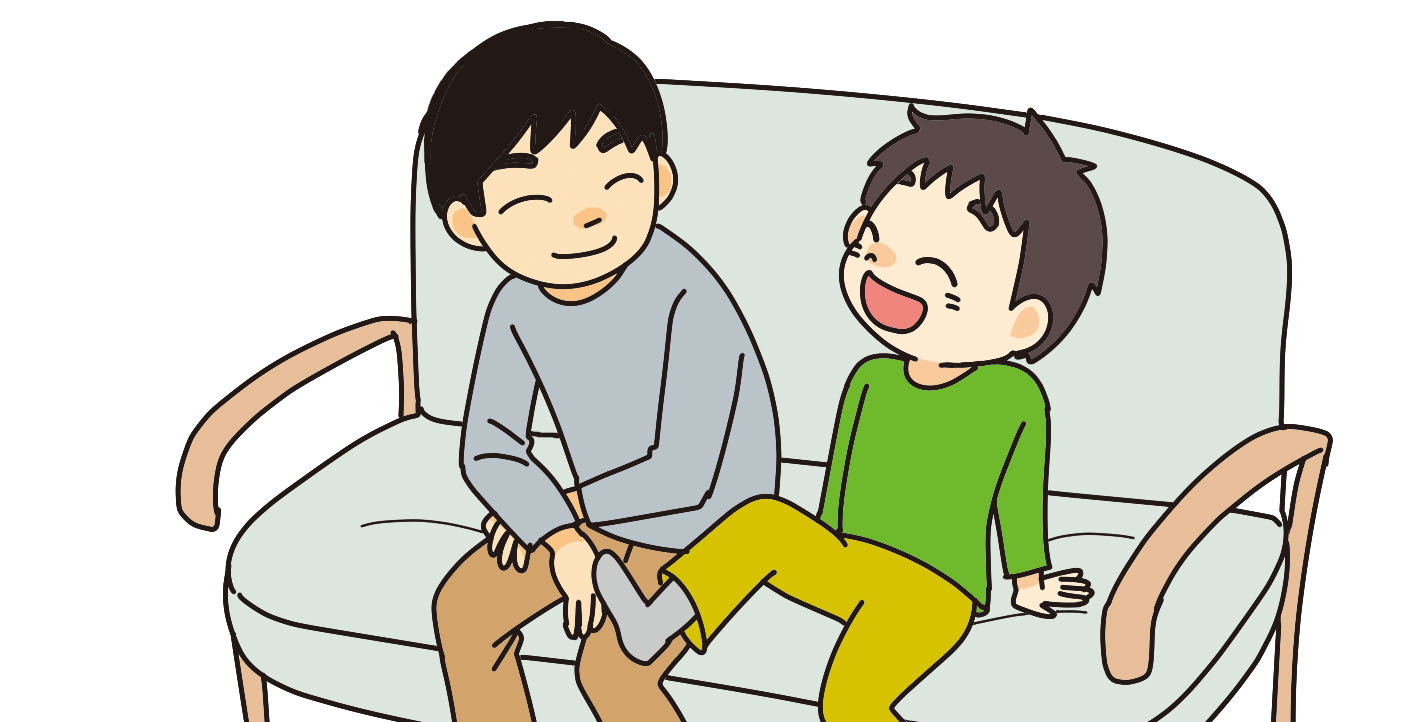 自宅でソファーに座って会話を楽しむ親子