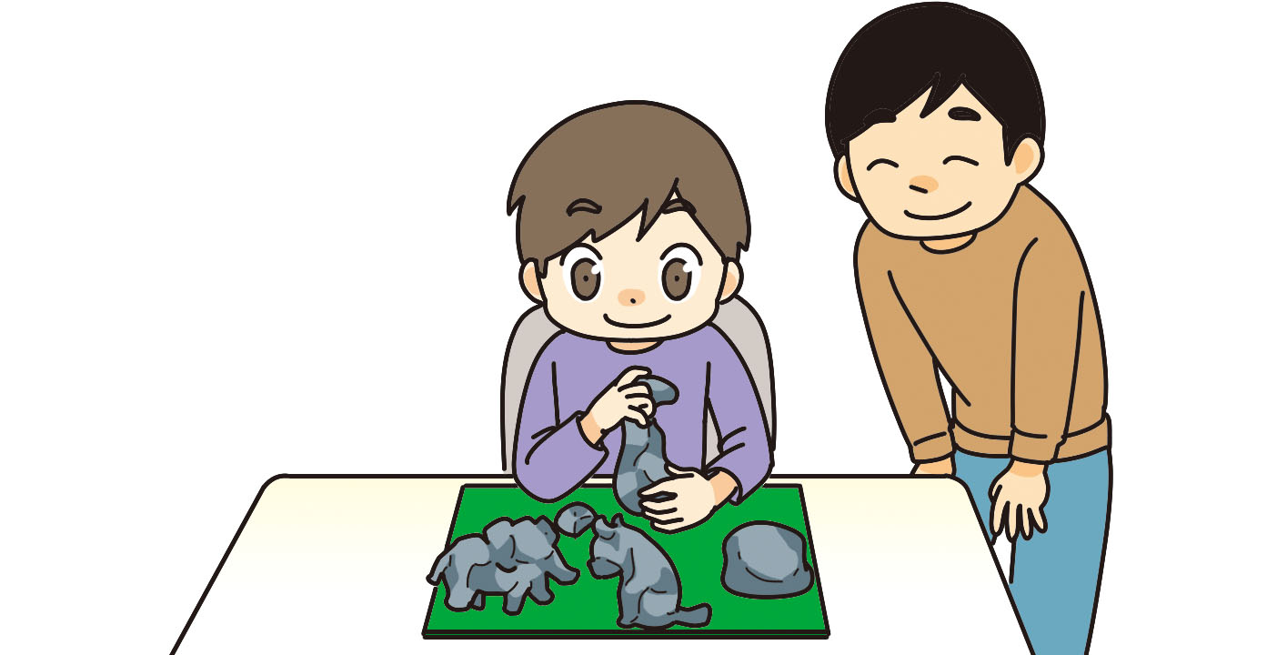 粘土で動物をつくっている子どもと後ろから見守る親