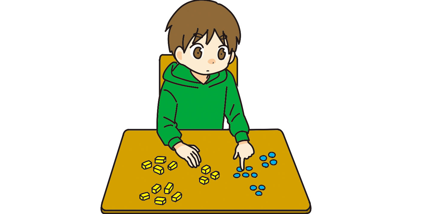机に並べてあるおはじきを数える子ども