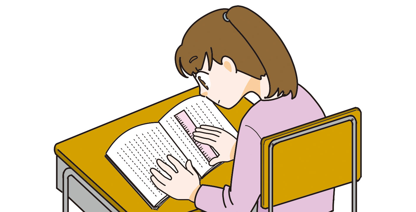 読んでいる本の行に定規を当てる子ども